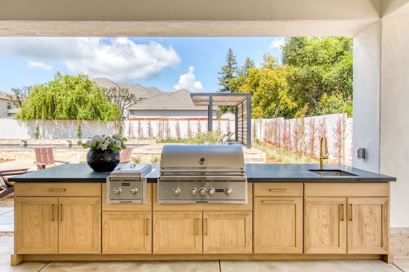 Outdoor kitchen with weatherproof oak cabinetry and built-in grill